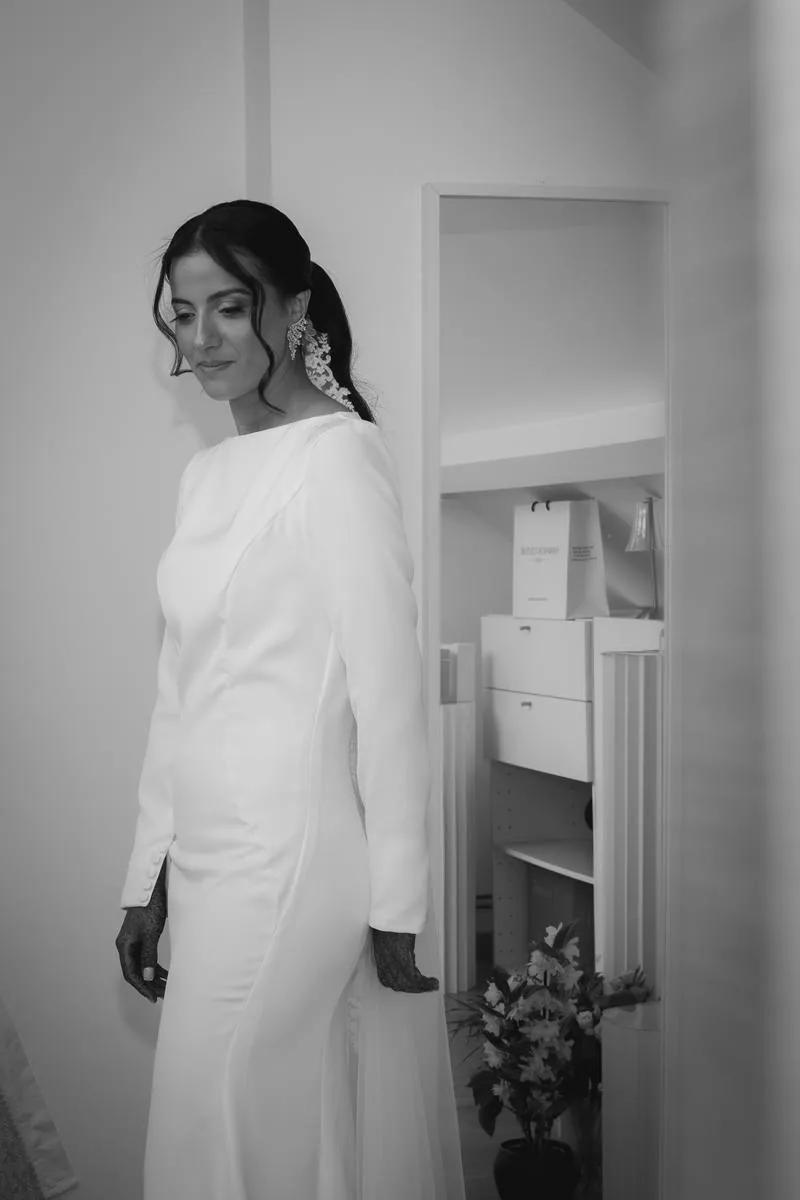 Mariée en robe blanche dans l'entrée de la maison