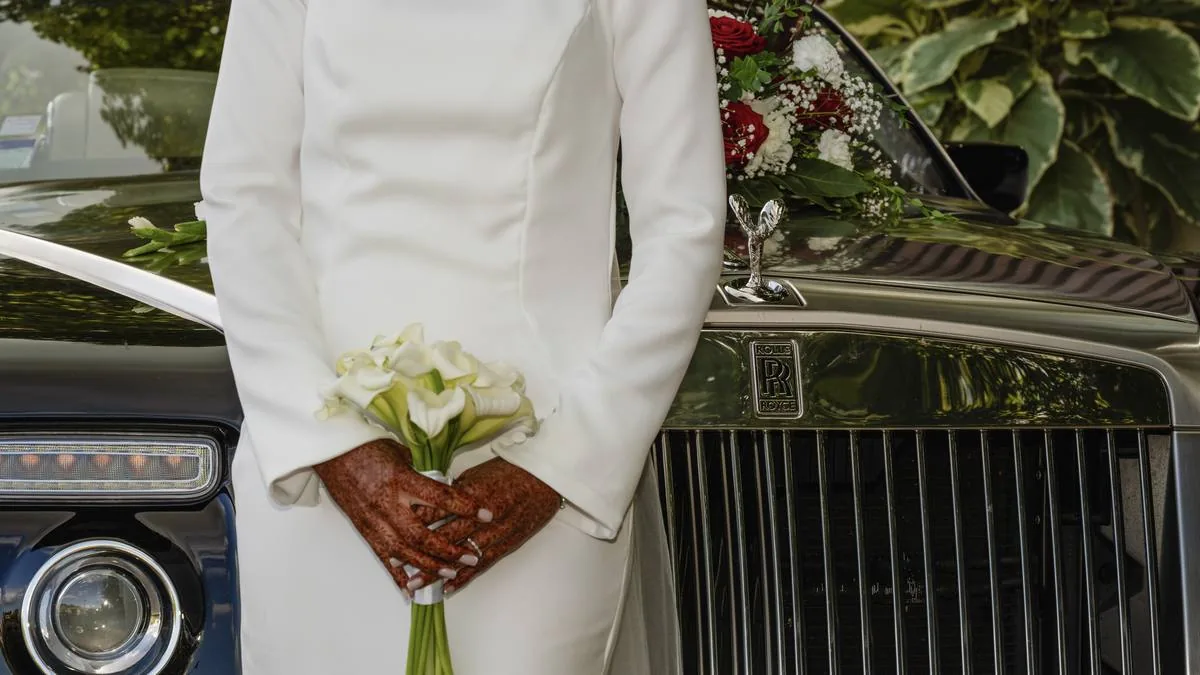 Marié tenant le bouquet près de la voiture