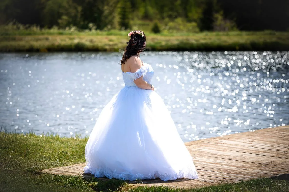 Mariée en robe bouffante au bord de l'eau