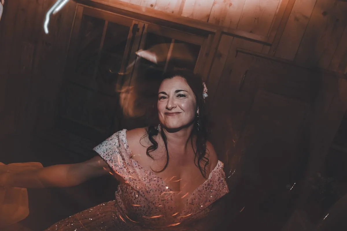 Mariée en robe rose pailletée dans une salle chaleureuse