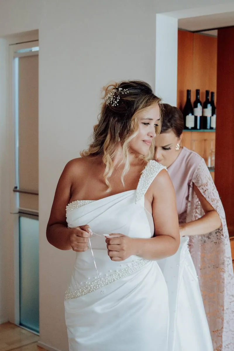 Mariée aidée pour ajuster sa robe