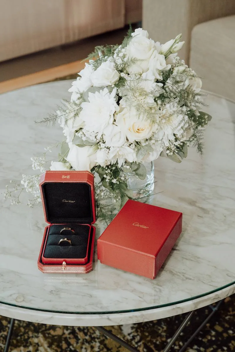 Détail des alliances et du bouquet posés sur une table